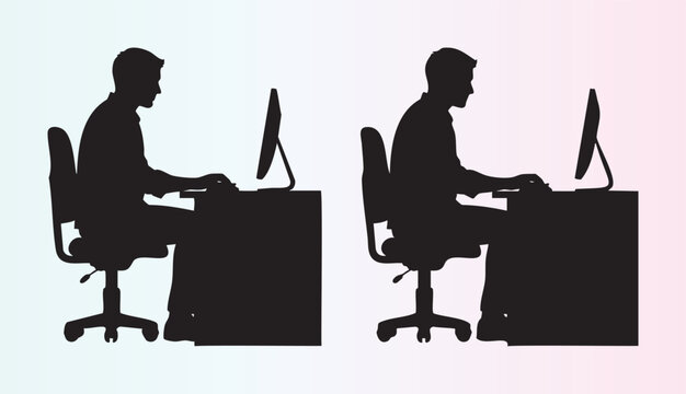 Silhouette of a person sitting at a desk working on computer in office environment