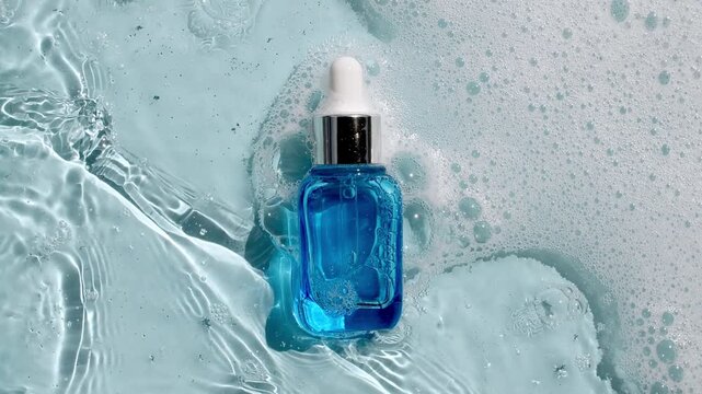 Bottle with a pipette for oil, toner, emulsion on water texture background surface with bubbles of white soapy foam. Women's cosmetics skincare, body care. Products advertisement spa, relaxation. 4k