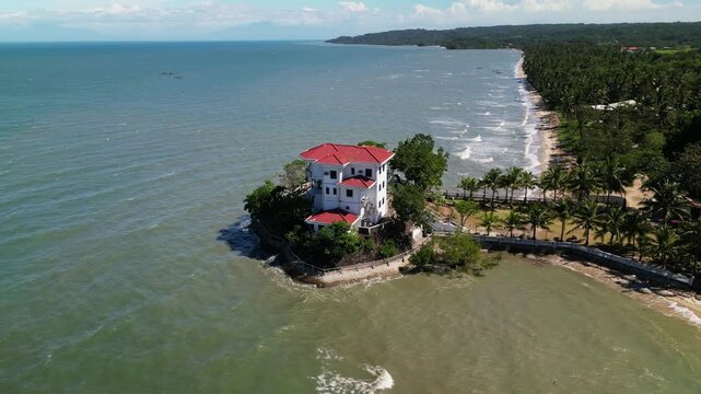 Aerial view of a heritage seaside house on a small island with surrounding waters and tropical vegetation in Roca Encantada, Guimaras, Philippines
