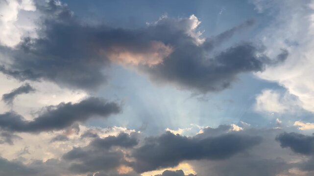 Dramatic Sunlight Piercing Through Dark Clouds in a Blue Cinematic Sky