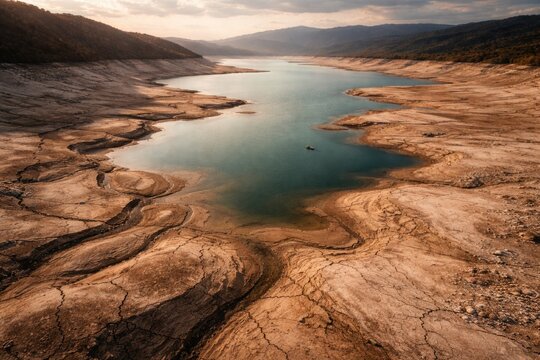Climate induced drought causing significant drop in lake volume from aerial vantage