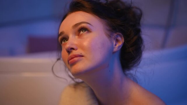Serene woman with closed eyes breathing deeply while meditating in a floating tank. Floating therapy and relaxation in a sensory deprivation tub