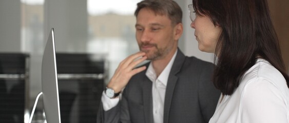 Naklejka premium Business people collaborating on a computer screen, analyzing financial data and marketing charts, strategizing business growth and investment returns in a corporate office meeting. Businesspeople
