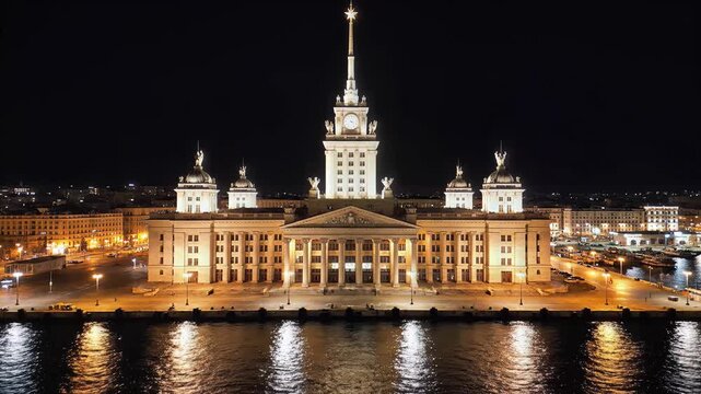 Illuminated Stalinist Empire Style Building at Night Reflecting in Water.