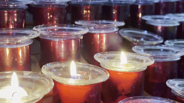 Close up of burning red votive candles