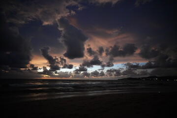 Fototapeta premium Dramatic twilight clouds over a dark ocean shore
