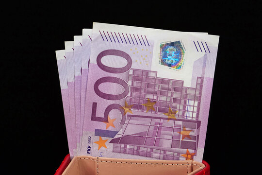 A red wallet with five 500 Euro bills inside, representing a total of 2500 Euros, ideal for showcasing cash flow and financial management