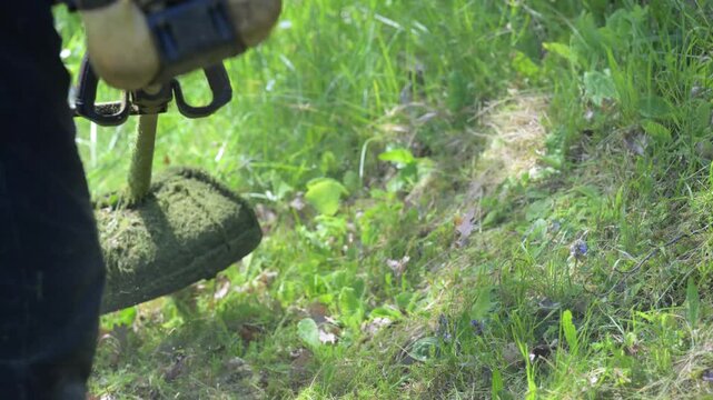 ANZIANO LAVORI NEL PRATO CON DECESPUGLIATORE