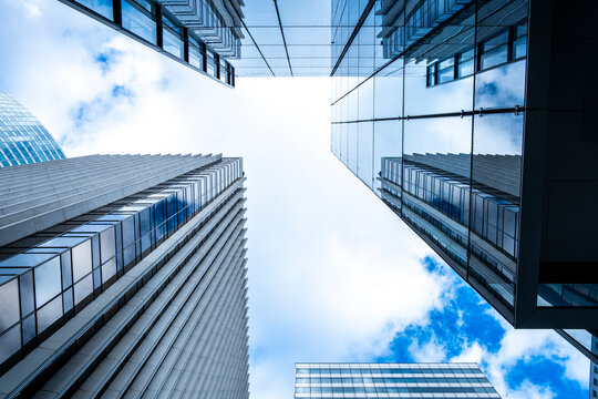 Sky and clouds frame architecture skyscraper office buildings with steep perspective looking up in Paris La Defense financial quarter highrise