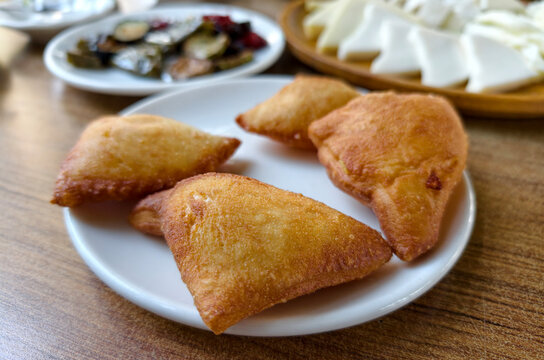 Savory pastries served with side dishes at a dining table during lunch in a casual setting