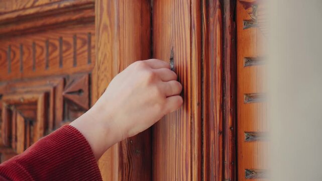 Close-up of a hand knocking on a wooden door. Entrance, arrival, communication and request concept. High quality 4k footage