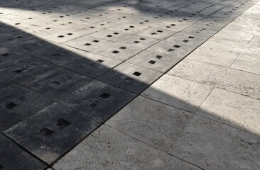 Fototapeta premium Patterned ground with light and shadow on rough textured square and rectangular tiles