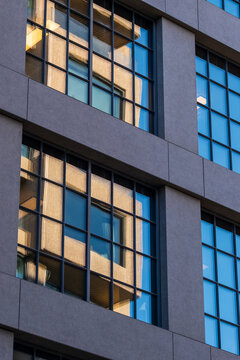 Modern abstract pattern in architecture where windows on facade reveal grid geometry and glass reflections for a clean contemporary city backdrop