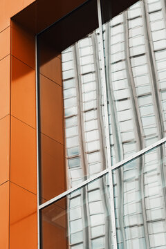 Modern abstract facade of architecture with orange panels glass windows and clean lines where geometry builds a graphic urban composition