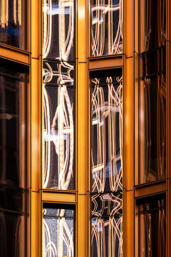 Abstract modern architecture in golden facade where glass windows reflections create symmetry and pattern for an elegant night city mood