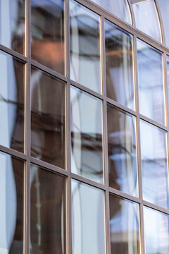 Modern abstract architecture pattern in windows facade where glass reflections meet grid geometry for a minimalist contemporary building closeup