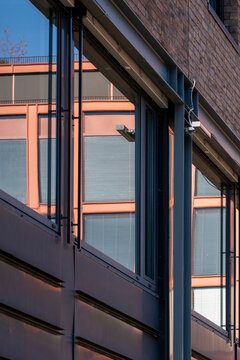 Modern brick architecture with abstract windows on exterior facade showing lines geometry and shadows for a graphic industrial city closeup