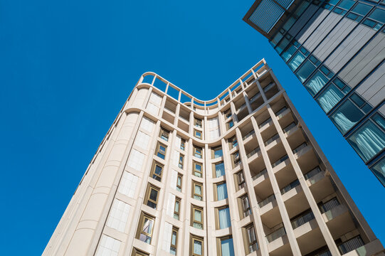 Newly constructed hotel complex building in central London. Seen against a clear early summer sky. A neighbouring apartment building is on the right.
