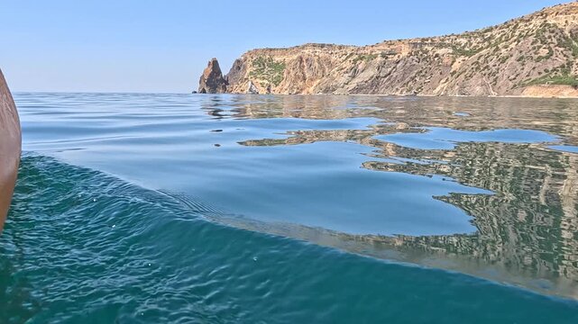 Sea, Ocean, Water calm surface waves by beautiful rocky coast under clear blue sky