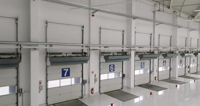 Interior shot of a warehouse showing a series of numbered loading dock doors with blue frames