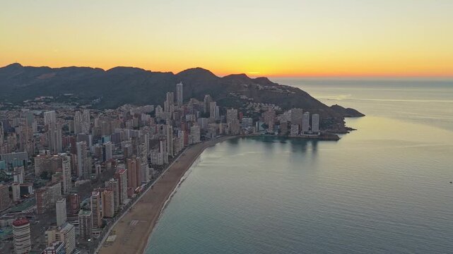 Aerial view of benidorm cityscape and beach during a golden sunrise