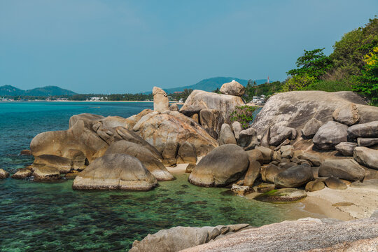 Iconic Hin Ta Grandfather Rock coastal formation on Koh Samui with weathered granite shapes rising above clear turquoise water near Lamai beach