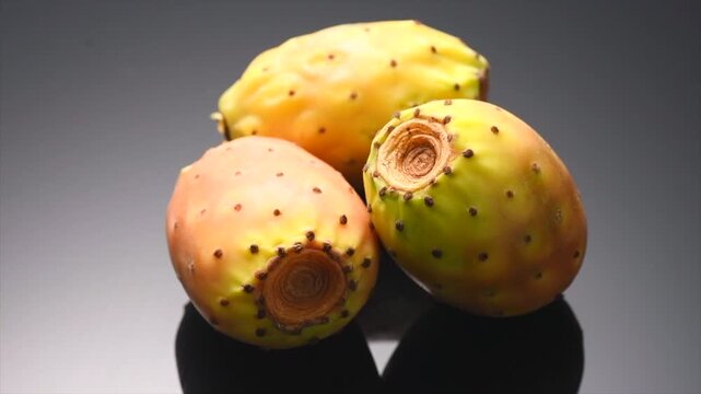 Prickly pear cactus, Opuntia edible fruit macro shot. Fresh tasty sweet whole exotic fruits. Opuntia ficus indica rotating on black background 