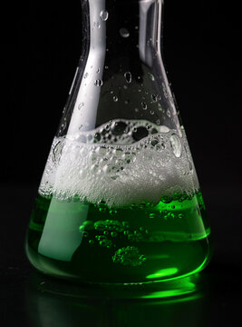 Science experiment with green bubbles in a flask.