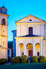 View of the facade and bell tower of Madonna del Sasso Sanctuary, over the western banks of the lake (UNESCO Site), illuminated by artificial lights at the summer dusk. © stefanopez