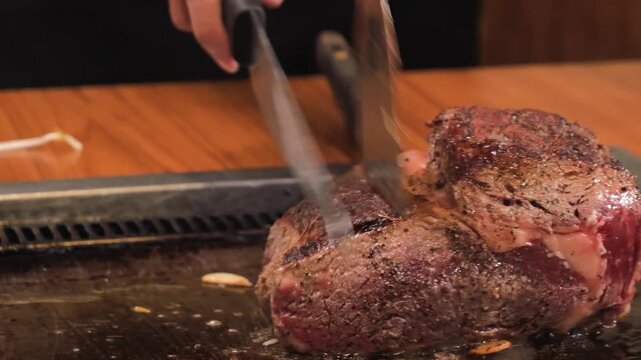 Close-up video of a perfectly cooked medium-rare standing rib roast being prepared at a commercial kitchen carving station. The footage highlights the rich, savory crust and tender, marbled center of 