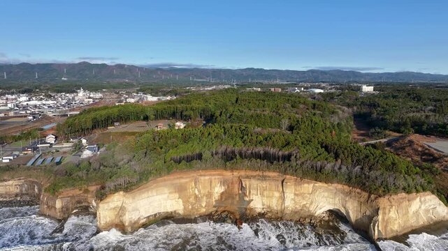 Aerial view of coastal sandstone cliffs with strata and forest in Tomioka, Fukushima Japan