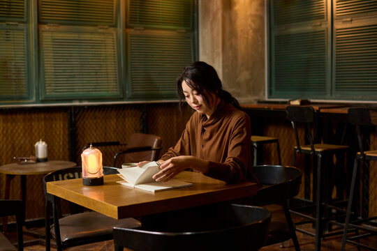 A woman enjoys a cup of tea and a good book at a serene tea house