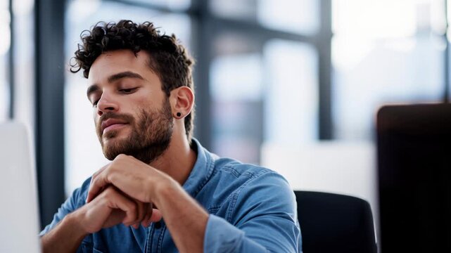 Man reflecting at workstation with laptop, product manager pauses to gather thoughts in glasswalled office, hands folded under chin then opens to intent gaze,