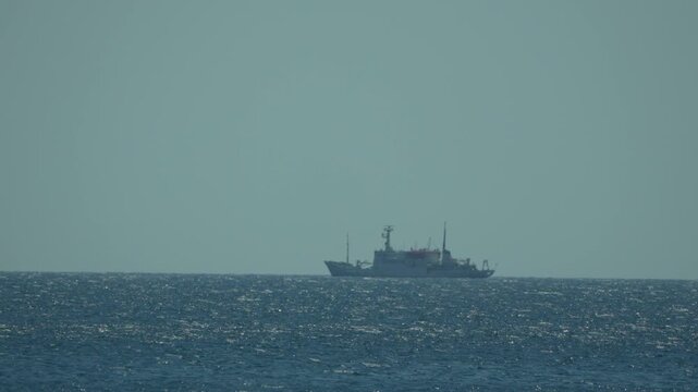 Ocean sea ship navigates vast deep blue waters under clear sky on bright day for maritime travel and exploration
