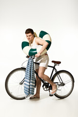 Naklejka premium Stylish young man ready for summer adventures with a bicycle and beach essentials