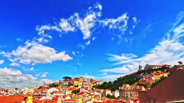 Lisbon old town viewpoint over rooftops. Skyline cityscape time lapse facing Alfama, Graca, Anjos and Martim Moniz neighbourhoods. Historic centre terracotta roofs. Portugal time-lapse vibrant bright