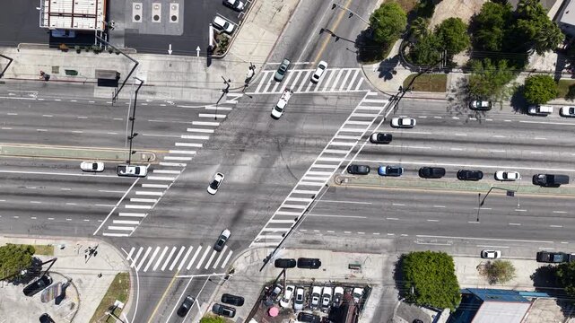 Cinematic daytime aerial drone footage captured rising upward from the intersection of Venice Boulevard and Hauser Boulevard in Los Angeles.