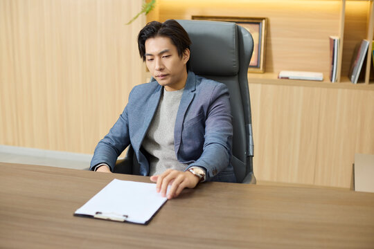 A businessman examines documents at his workstation