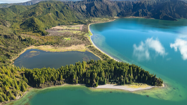 Aerial view of the serene Lagoa do Fogo's turquoise waters meet the rugged volcanic crater rim, a symphony of green and blue, Ponta Delgada, Azores, Portugal.
