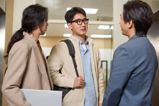 Business associates conversing while waiting for the elevator