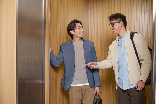 Business people share an elevator ride in their workplace