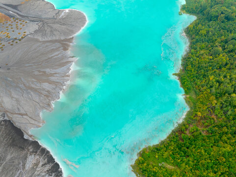 Aerial view of striking contrast where vibrant turquoise waters meet lush green forests and desolate grey terrain, Tuzla, Bosnia and Herzegovina.