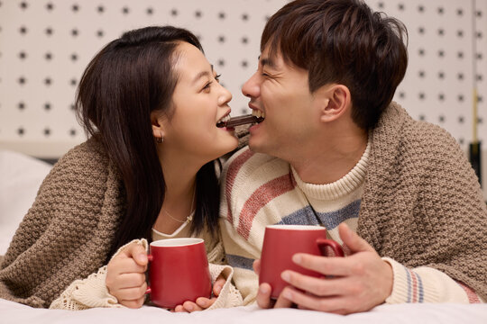 A lovely young couple stays cozy in bed
