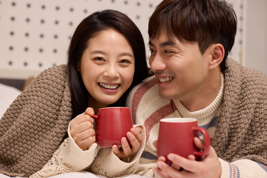 A lovely young couple stays cozy in bed