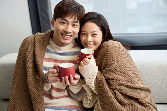 A young couple snuggling closely on the sofa