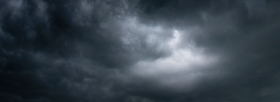Dark thunderstorm clouds rainny season. Meteorology danger windstorm disasters climate. Banner Dramatic dark storm clouds black sky background. Dark thunderstorm clouds rainny atmosphere.