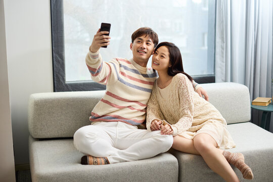 A young couple snuggling closely on the sofa
