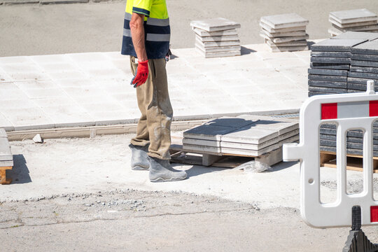 Construction worker standing near paving tiles The Concept of urban renewal