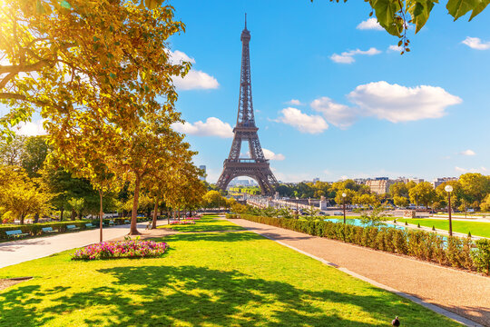 The majestic Eiffel Tower in Paris rising above Trocadero fountains against a backdrop of expressive storm clouds