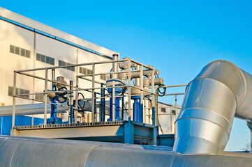 Obraz premium pipeline and elements of a thermal power plant against a blue sky